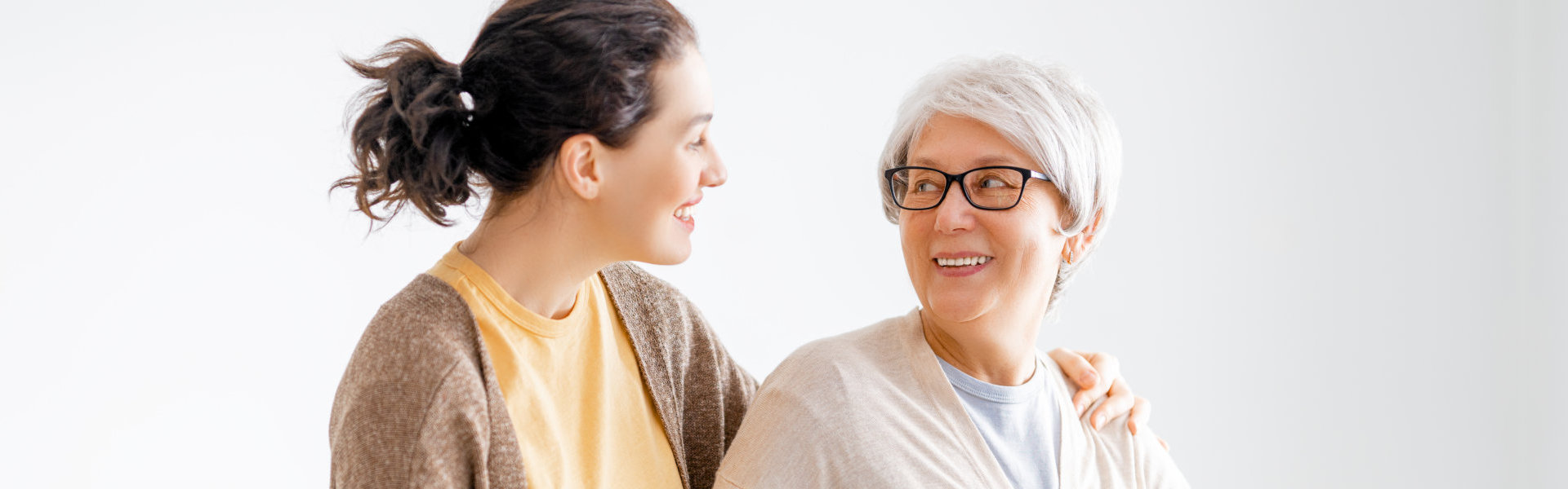 aide and senior woman looking at each other and smiling